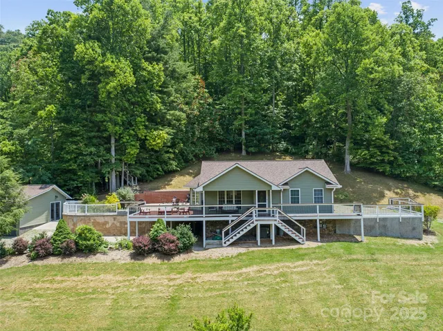 an aerial view of a house with swimming pool and next to a yard