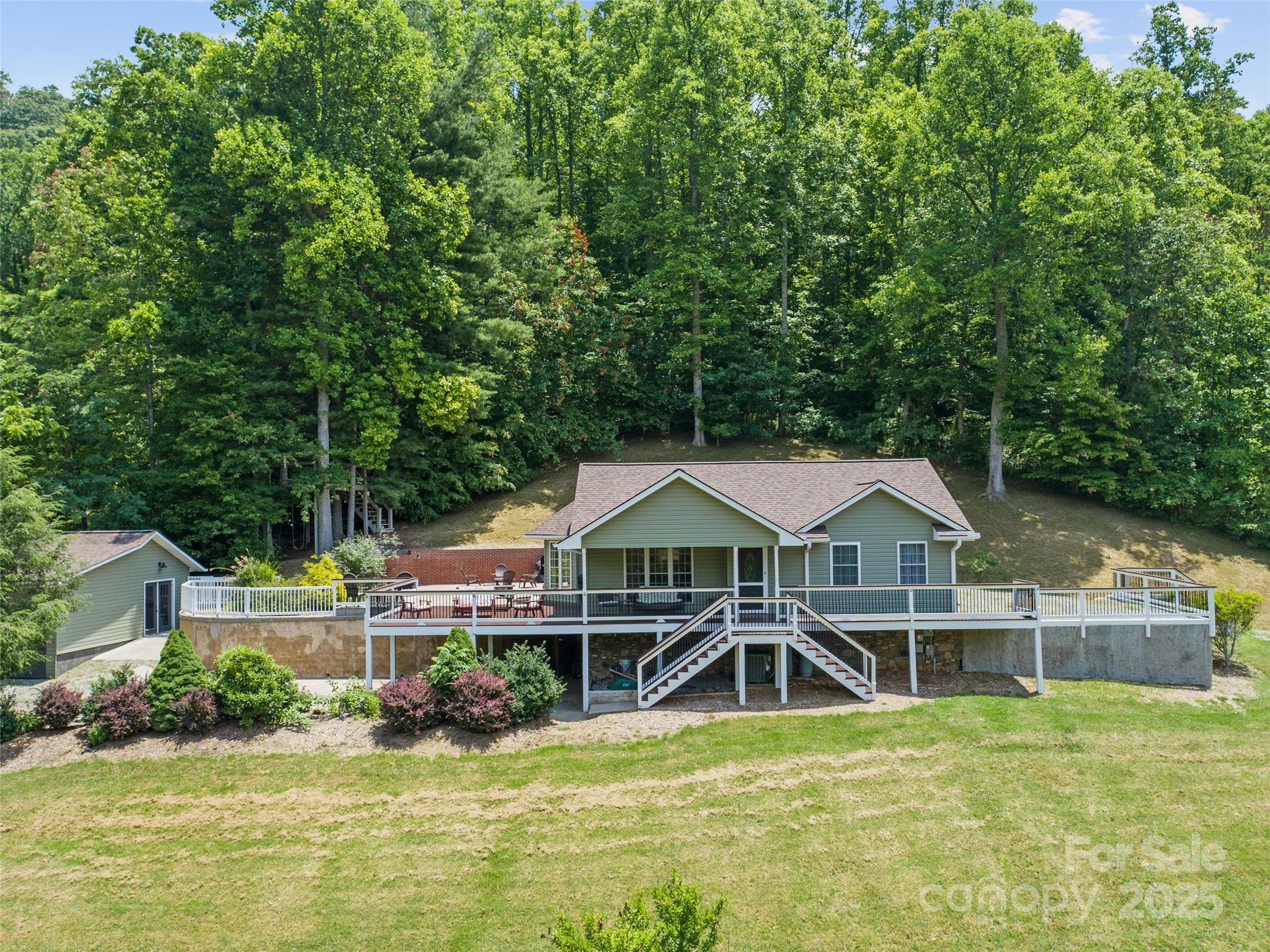 an aerial view of a house with swimming pool and next to a yard