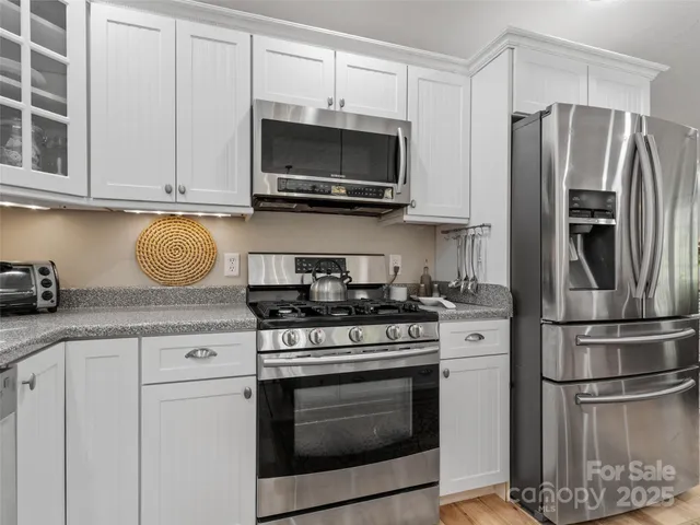 a kitchen with stainless steel appliances granite countertop a stove microwave and refrigerator