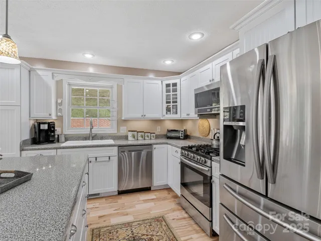 a kitchen with stainless steel appliances granite countertop a refrigerator sink and stove