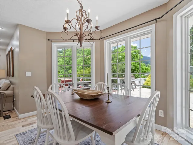 a dining room with furniture a chandelier and wooden floor