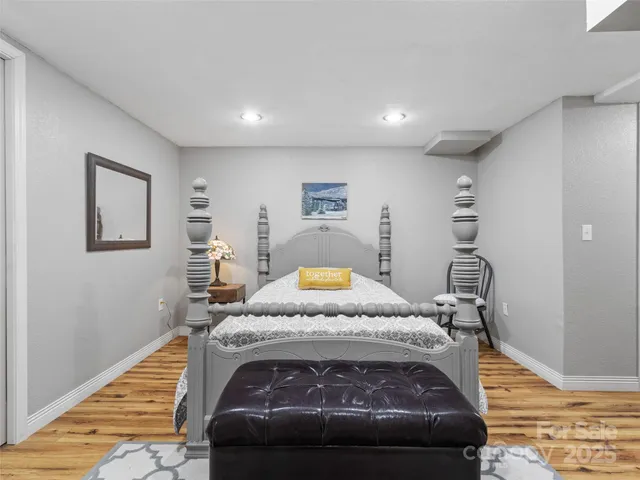 a bedroom with a bed and wooden floor