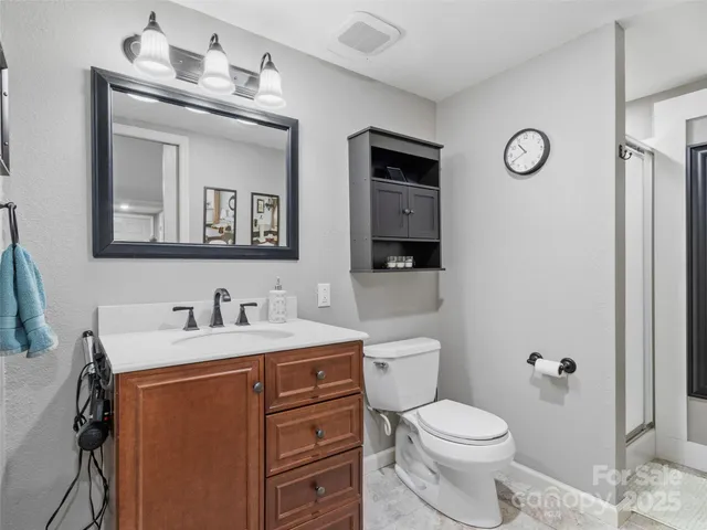 a bathroom with a toilet sink vanity and mirror