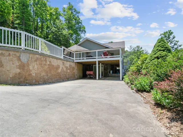 an aerial view of a house with a yard and trees all around