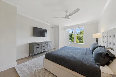 a bedroom with a bed and a flat tv screen on the dresser