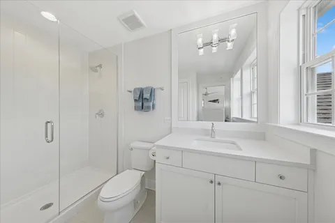 a bathroom with a sink a toilet and shower