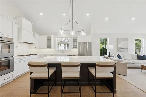 a dining room with a table chairs and a kitchen view