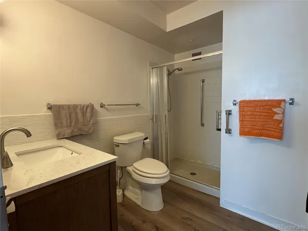 a bathroom with a sink a toilet and shower