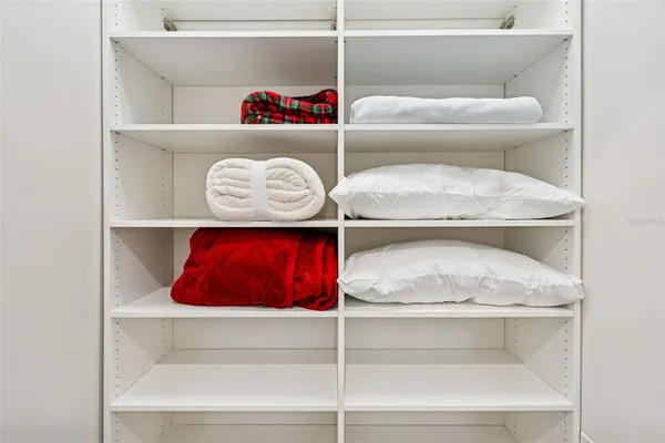 a view of a patio with couches table and chairs under an umbrella with palm trees