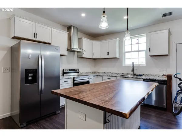 a kitchen with kitchen island a counter space a sink appliances and cabinets