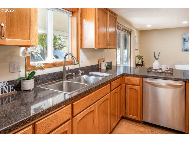 a kitchen with stainless steel appliances granite countertop a sink a counter space and cabinets
