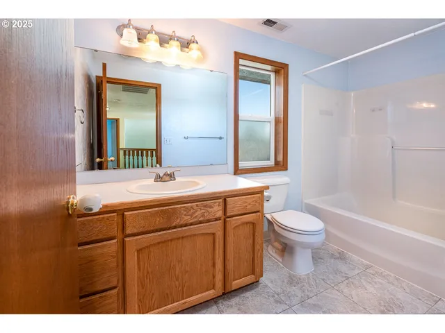 a bathroom with a toilet a sink a tub and mirror