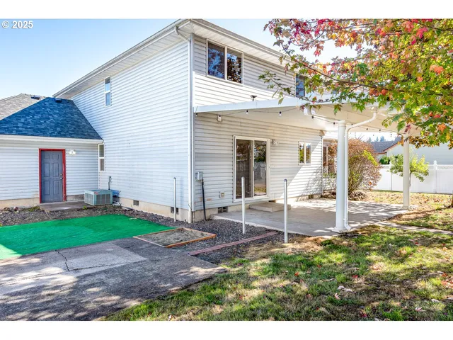 a view of a house with backyard and a tree