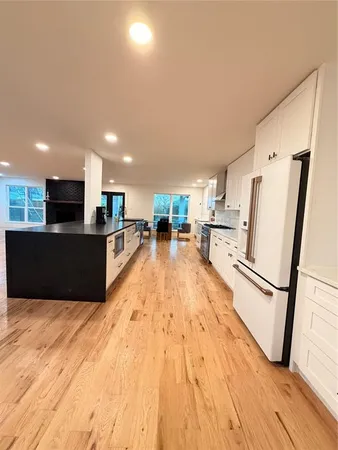 a large kitchen with stainless steel appliances granite countertop a refrigerator and a stove top oven