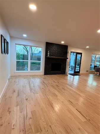 an empty room with wooden floor and fireplace