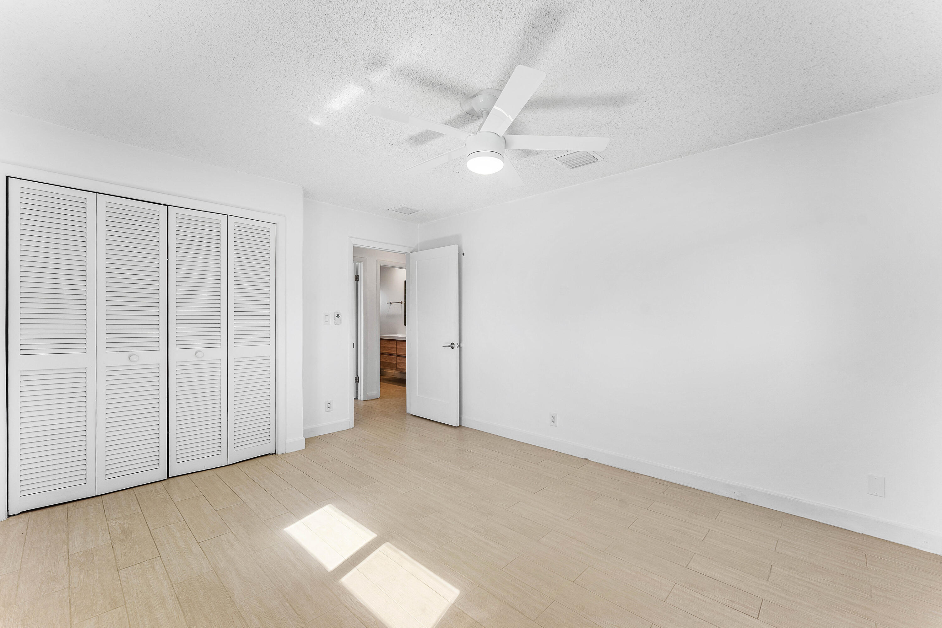 7643 Overlook Road Lake Worth, FL 33462 - Photo 11 of 29 an empty room with a ceiling fan and closet area