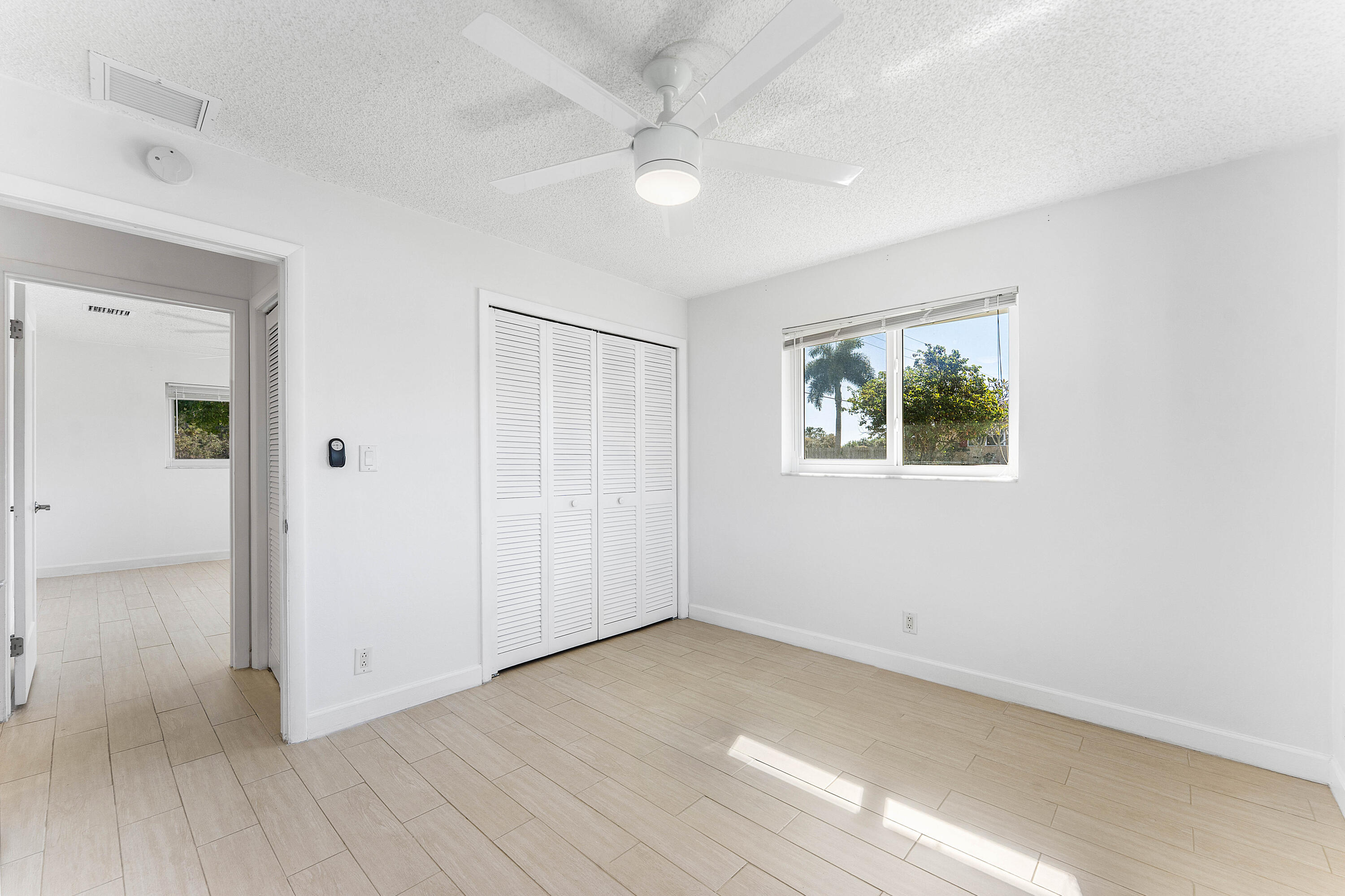 7643 Overlook Road Lake Worth, FL 33462 - Photo 14 of 29 an empty room with wooden floor and windows