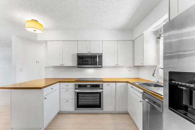 a kitchen with cabinets appliances and a counter space