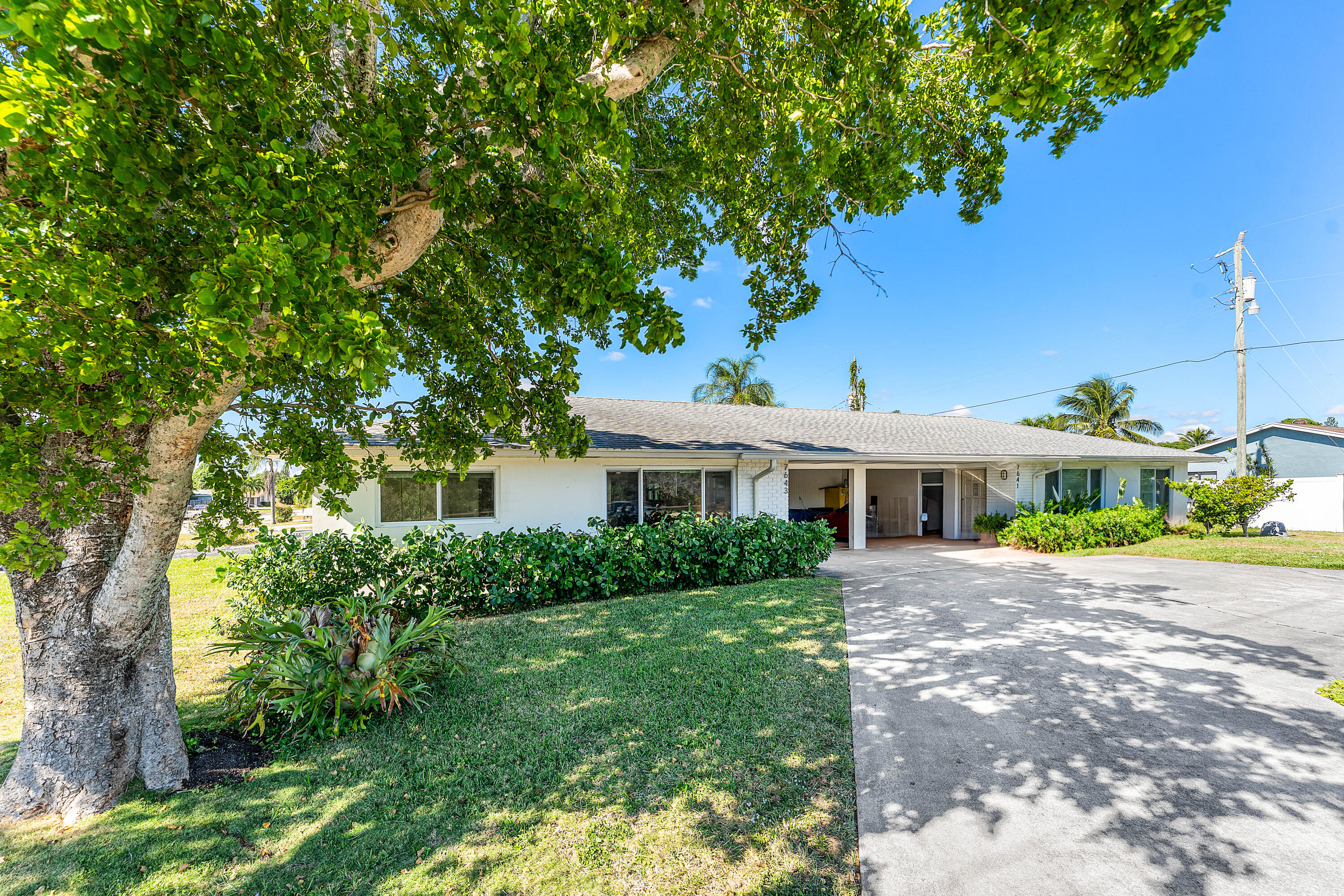 7643 Overlook Road Lake Worth, FL 33462 - Photo 26 of 29 a front view of a house with a yard and potted plants