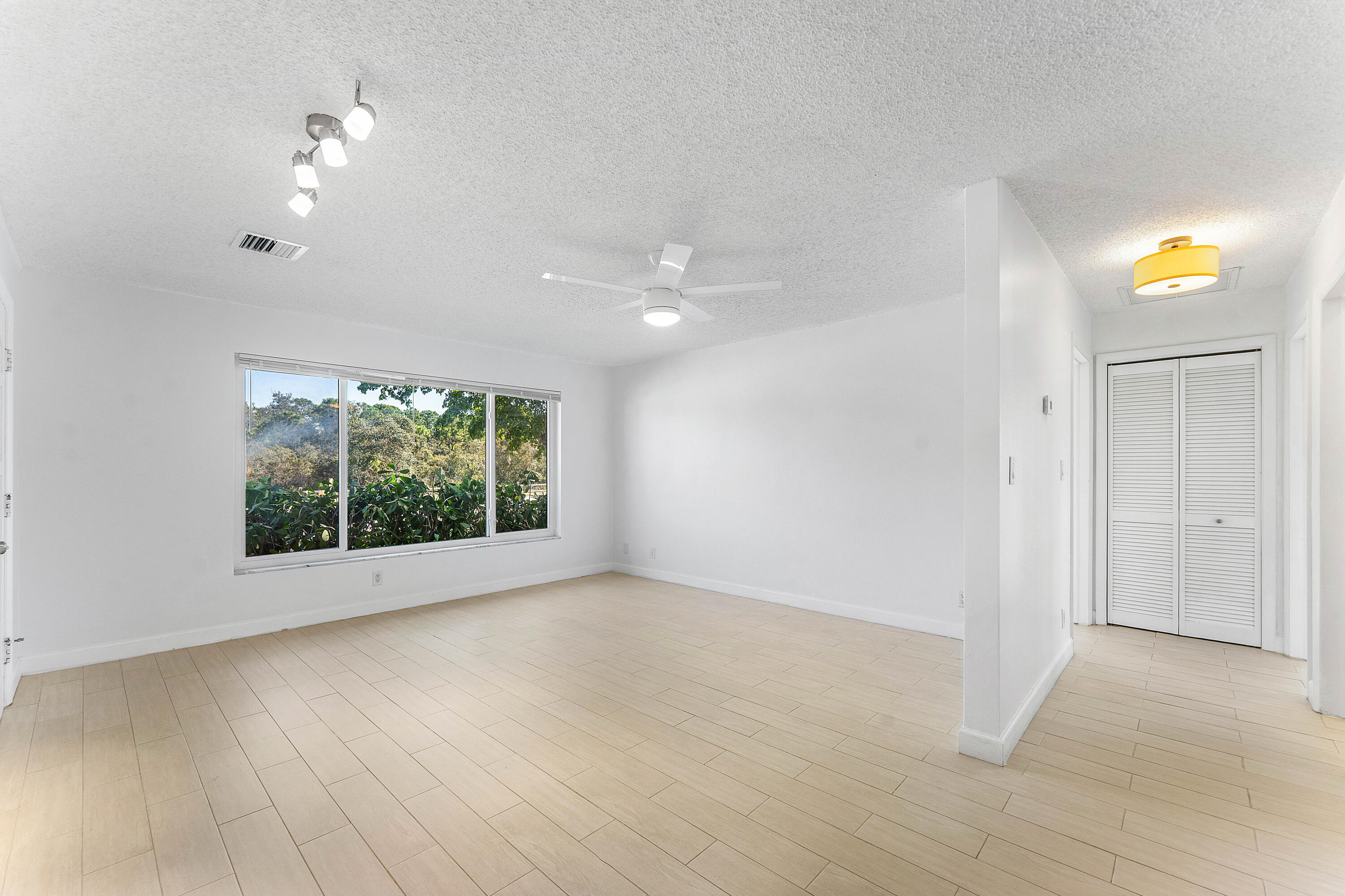 7643 Overlook Road Lake Worth, FL 33462 - Photo 9 of 29 an empty room with wooden floor and windows