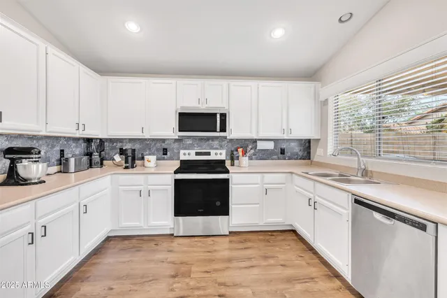 a kitchen with granite countertop white cabinets and white appliances