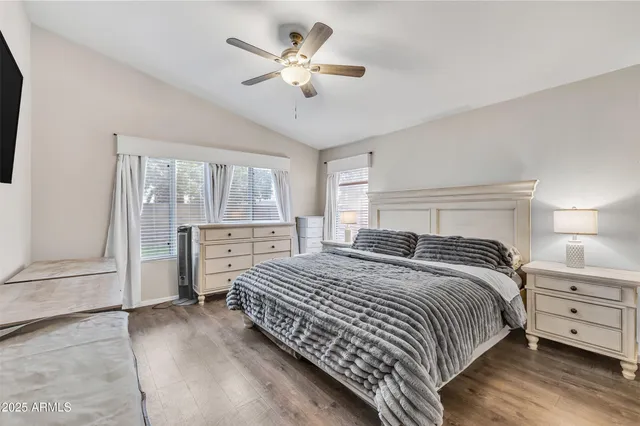 a bedroom with a bed chandelier and a window