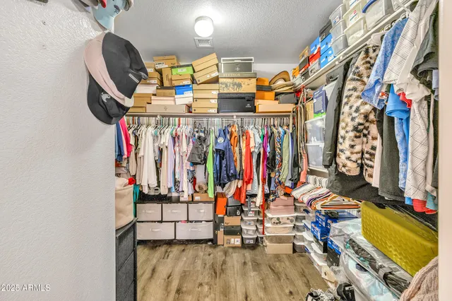 a view of walk in closet with clothes