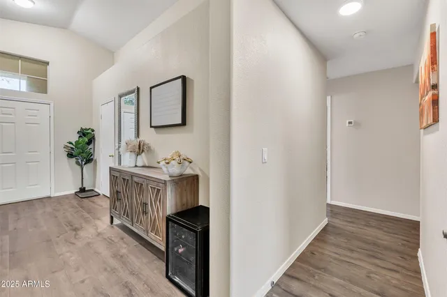 a view of a hallway with wooden floor and furniture