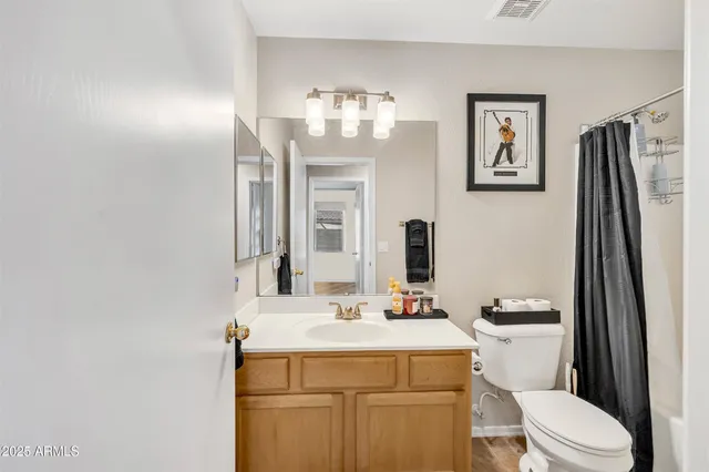 a bathroom with a sink a toilet and a mirror