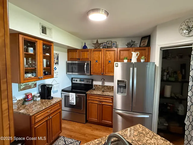 a kitchen with stainless steel appliances granite countertop a refrigerator stove and sink