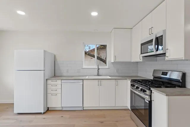 a kitchen with stainless steel appliances a stove microwave and sink