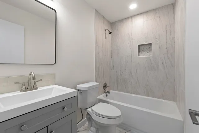 a bathroom with a sink a toilet and shower