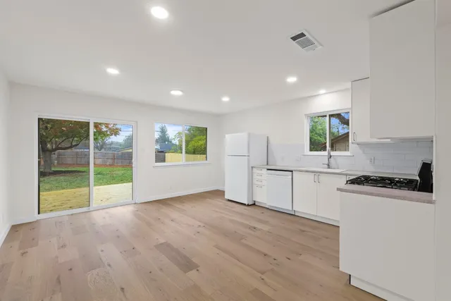 a view of kitchen with wooden floor and electronic appliances