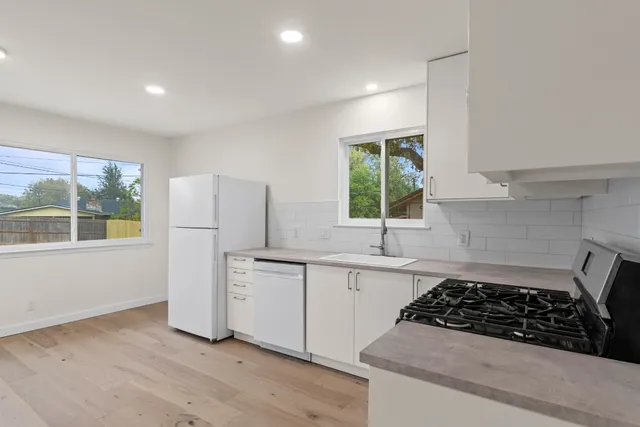 a kitchen with a stove a refrigerator and a sink