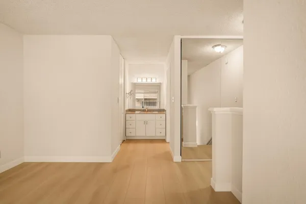 a view of empty room with wooden floor