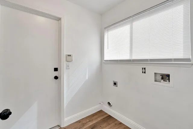 a view of a closet area with wooden floor