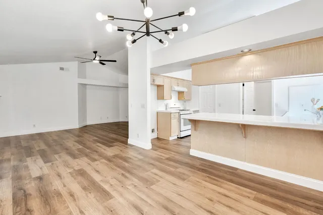 a view of a kitchen with wooden floor and cabinets