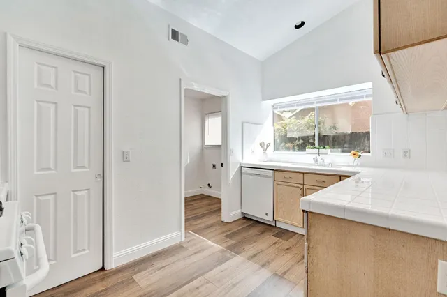 a kitchen with a sink cabinets and wooden floor