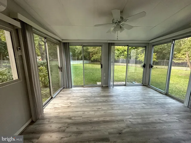 a view of an empty room with a large window with a ceiling fan