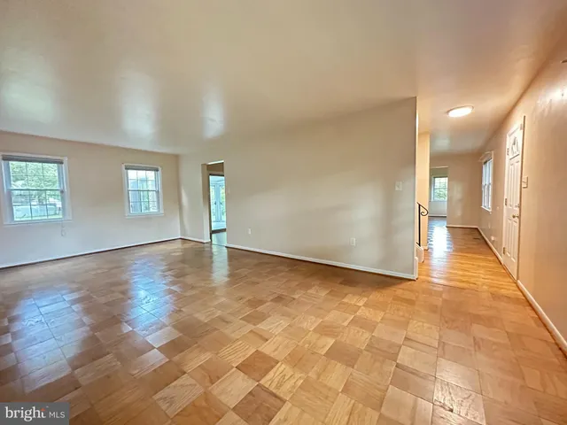 a view of a hallway with wooden floor and a living room