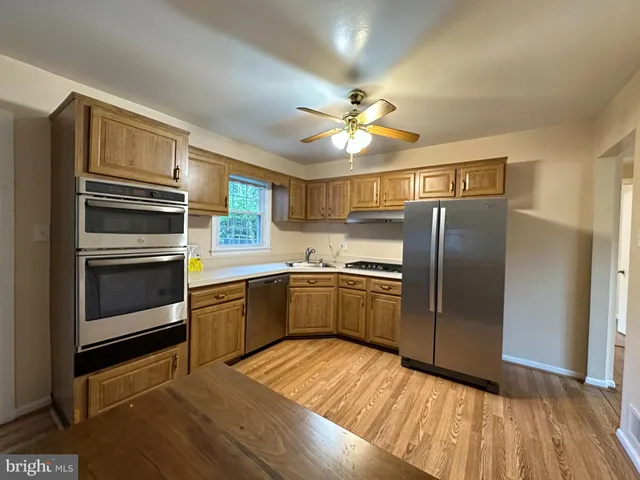 a kitchen with granite countertop stainless steel appliances and wooden floor