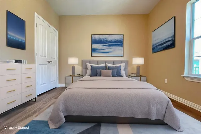 a bedroom with a bed and a flat tv screen on dresser