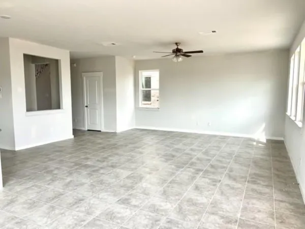 an empty room with windows and cabinet