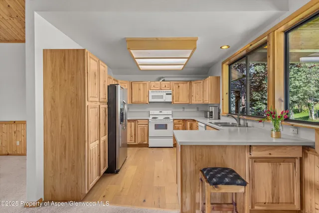 a kitchen with stainless steel appliances granite countertop a refrigerator a sink and a stove