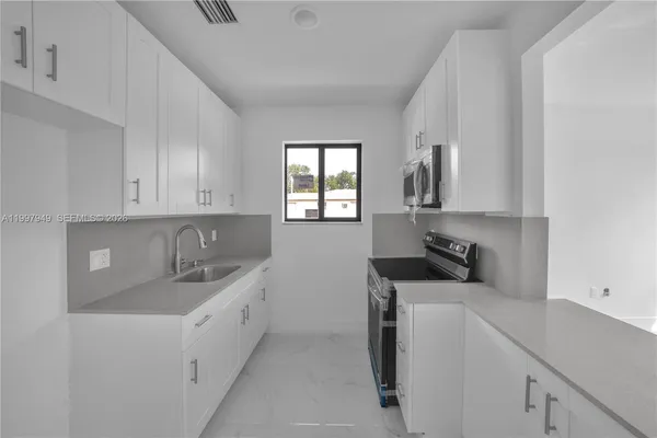 a kitchen with a sink a stove and cabinets