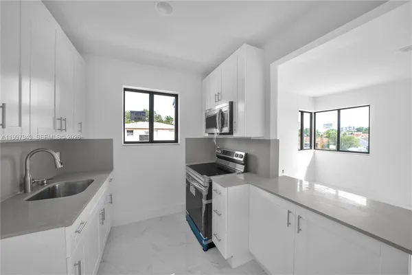 a kitchen with stainless steel appliances granite countertop a sink stove and cabinets