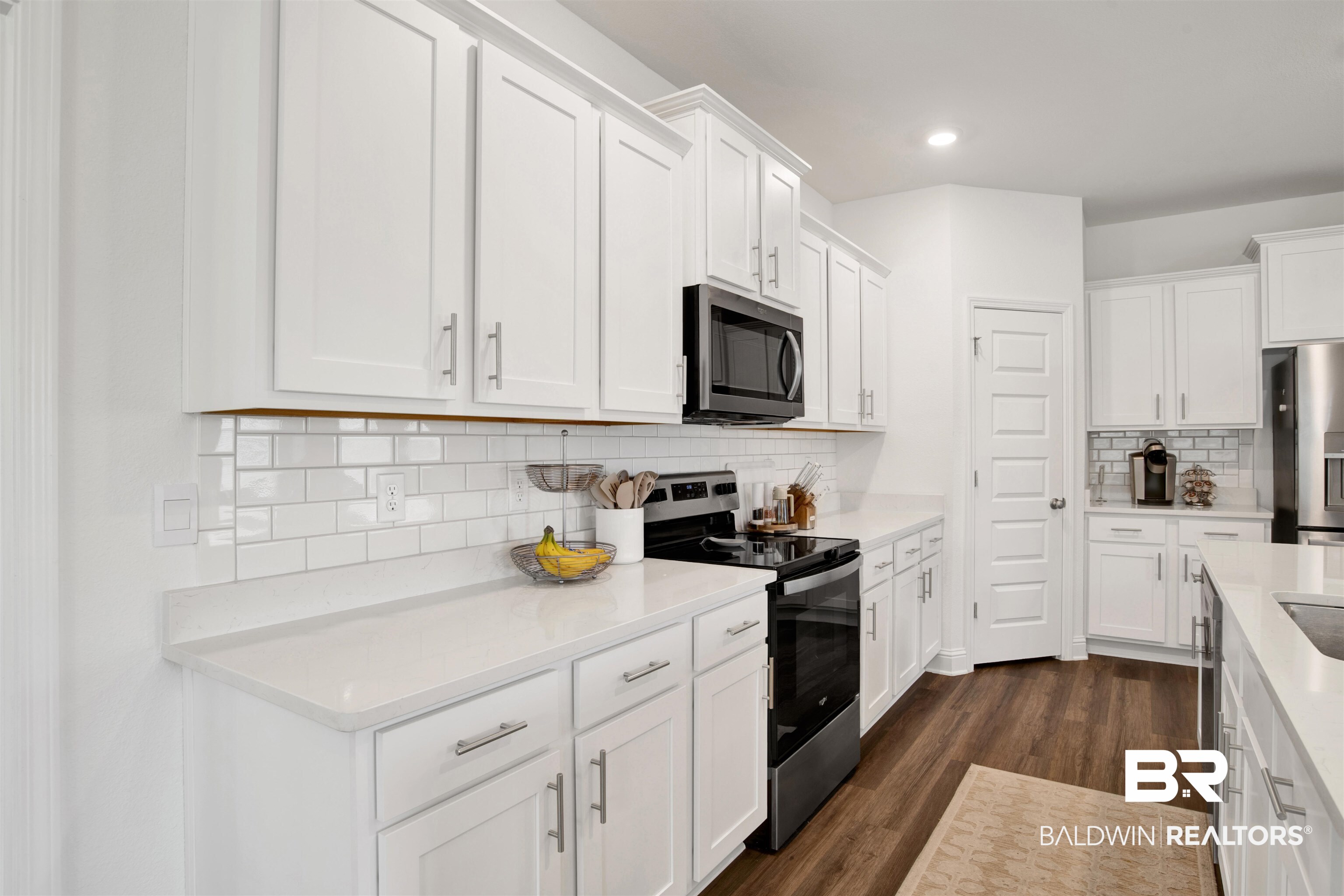 594 Shepard Street Gulf Shores, AL 36542 - Photo 21 of 51 Kitchen with stainless steel appliances, white cabinetry, dark wood-style flooring, light stone counters, and recessed lighting
