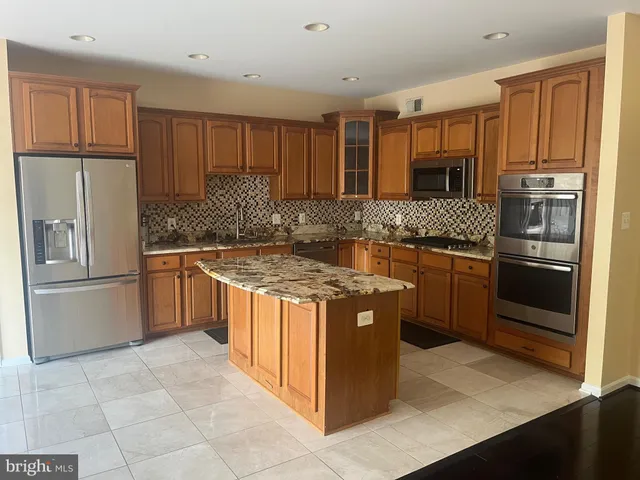 a kitchen with stainless steel appliances granite countertop a stove a refrigerator and a stove