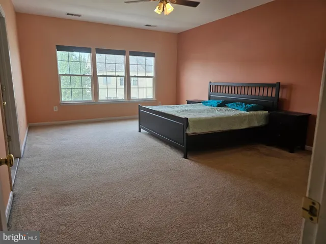 a spacious bedroom with a bed and a window