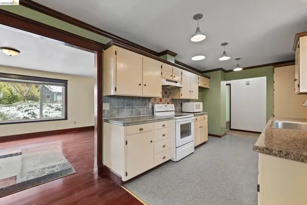 a large kitchen with stainless steel appliances granite countertop a stove a sink and a refrigerator